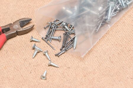 nails and screws on a wooden background