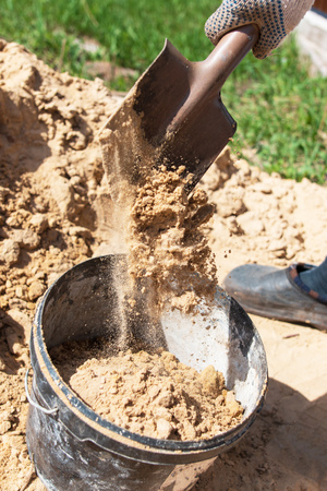sand shoveling in a bucketの写真素材
