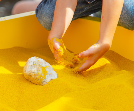 hands in yellow sandの写真素材