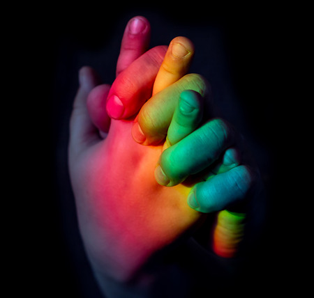 multi-colored hand on a black backgroundの写真素材