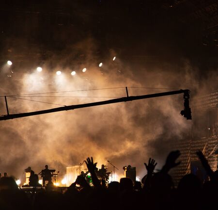 silhouettes of hands by spotlights at a concert