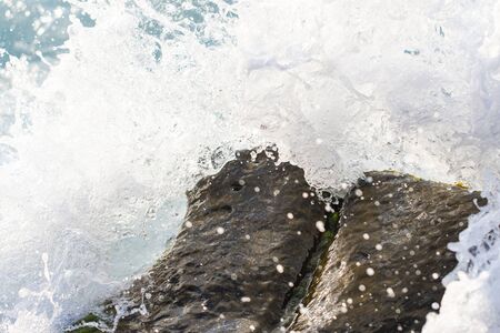 spray of sea water on the rocksの写真素材