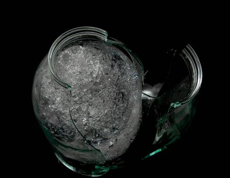 transparent ice and glass fragments on a black backgroundの写真素材