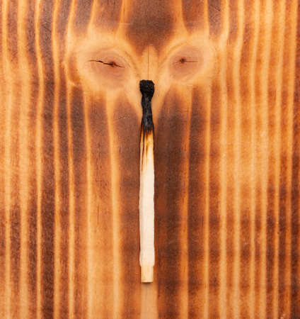 burnt match on wooden backgroundの写真素材