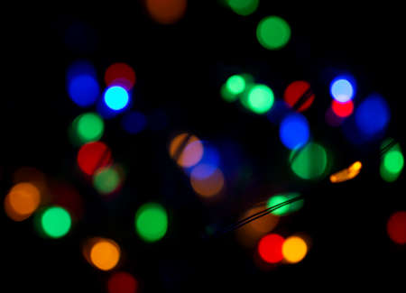 multicolored flashes of Christmas lights on a black background