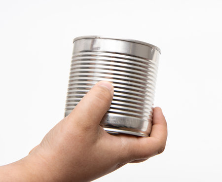 childrens hands open a tin can on a white background