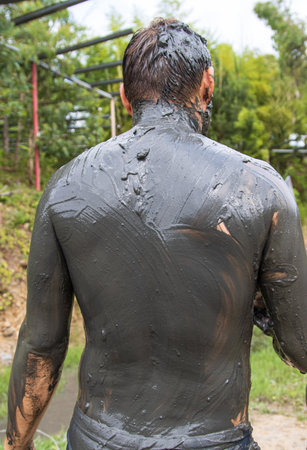 a man in medical black mud on vacationの写真素材