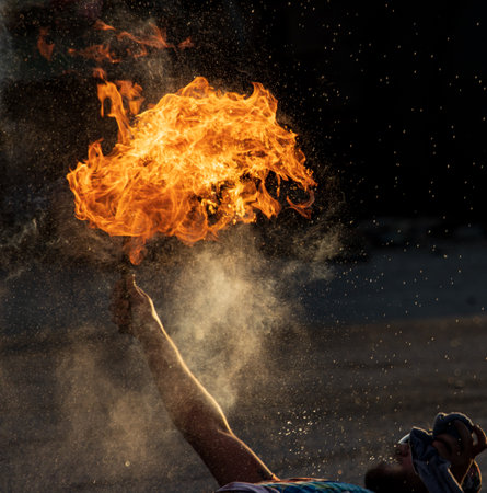 man blowing flames of fire as a backgroundの写真素材