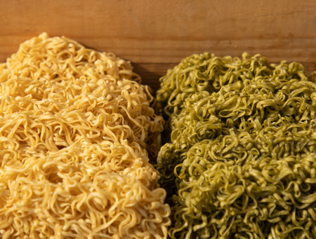 Two different types of noodles are displayed side by side. One is yellow and the other is greenの写真素材