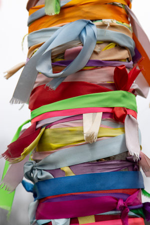 A bunch of colorful ribbons are tied together on a tree. The ribbons are of different colors and sizes, and they are tied in a way that they look like a colorful bundle. Concept of joy and celebrationの写真素材