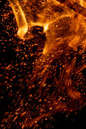 A fire is burning and the smoke is falling. The fire is orange and the smoke is black