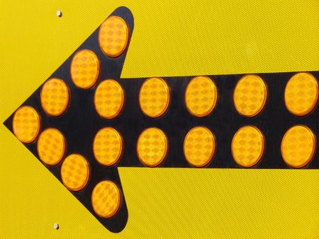 Left turn road sign with reflective discs.の写真素材