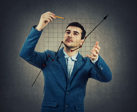 Creative businessman drawing a rising graph. Concept of analysing and informational strategy...
