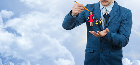 Family life insurance, protecting family, family concepts.Businessman holding a pencil in his hand try to draw happy family.
の写真素材