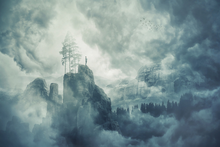 Man silhouette of the top of a mountain in the fog, enjoy the silence of the misty valley in the morning. Beautiful moment the miracle of nature. の写真素材