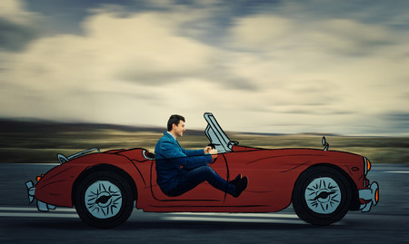 Profile portrait of a young smiling businessman driving a drawn race car on a imaginary highway.の写真素材