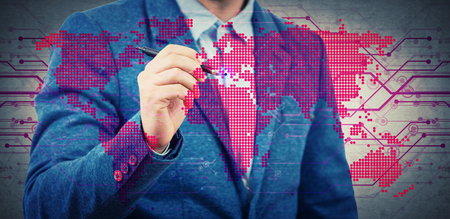 Businessman with a pen select a point on a digital world map hologram. Choosing the right place for business development. Virtual technology and cryptocurrency security concept. Double exposure.の写真素材