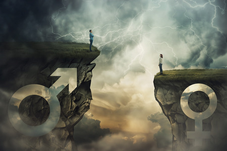 Gender gap idea and sex inequality concept as male and female sign shaped into stone cliff of different size as a metaphor of social issue distinct importance and discrimination in business.の写真素材