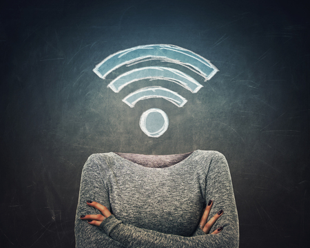 Surreal image young woman crossed armss and wifi symbol instead of head drawn over blackboard background. Dreaming of better network, excellent signal coverage concept.の写真素材