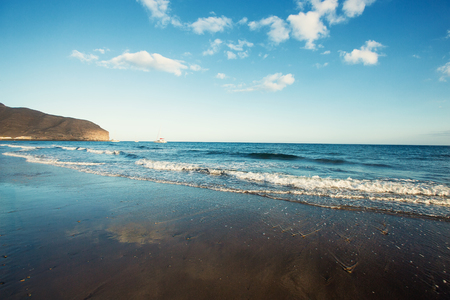 Sand beach, clear sea waves an blue sky.の写真素材