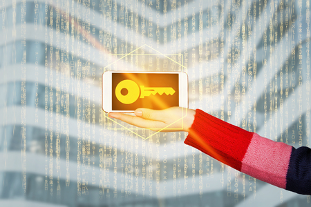 Woman hand holding a mobile phone golden cryptocurrency private key on screen. Fingerprint scanning, future security password cyber attack information protection.の写真素材