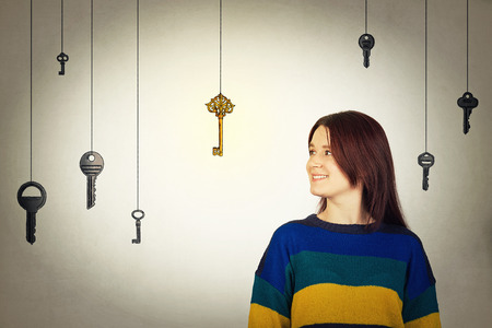 Young woman find the magic golden key. Aspirations and success concept, achievement and the right choice.の写真素材