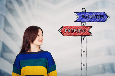 Young woman looking at a road sign sketch with solution and problem arrows showing to right and left side. Life choice, challenge and decision concept.の写真素材