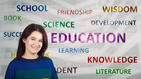 Smiling young woman student looking to camera. Different colorful words related to education concept...