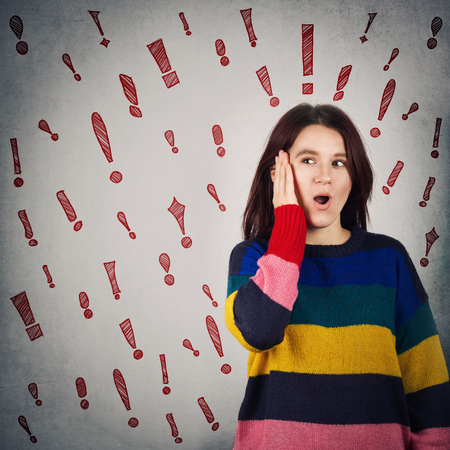 Surprised woman hand on her cheek holding mouth opened and exclamation marks like different thoughts...