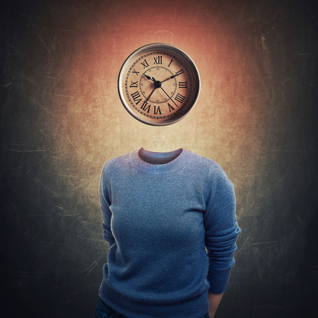 Surreal image anonymous woman with mystic clock instead her head over dark blackboard background. Emotional concept of time in educational process. Business planning symbol.の写真素材
