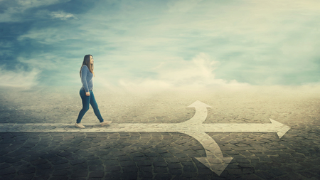 Surreal view as woman walking on a line in front of a crossroad splitted in three different ways as road arrows. Choosing the correct pathway between left, right and front. Difficult decision concept.の写真素材