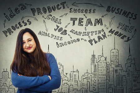 Young creative woman has great ideas as business sketches on the grey wall background. Self development and future planning.の写真素材