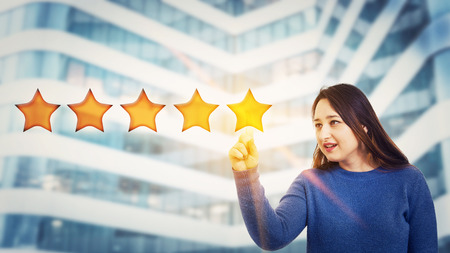 Young woman touching digital screen interface choosing five stars rating, positive feedback. Excellent customer service concept. Satisfied client voting survey.の写真素材