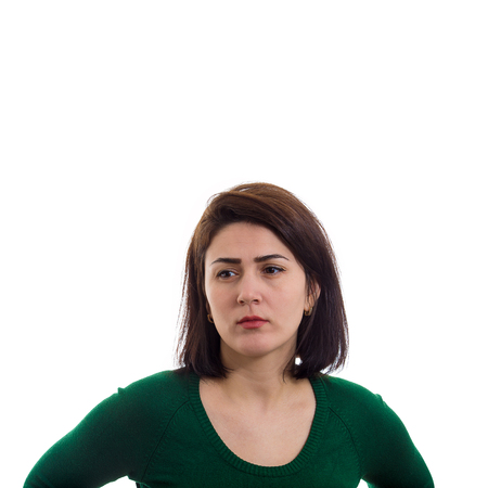 Serious and thoughtful young woman looking sad isolated over white background.の写真素材
