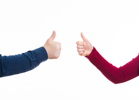 Close up of man and woman hands giving thumbs up positive gesture isolated on whiteの写真素材