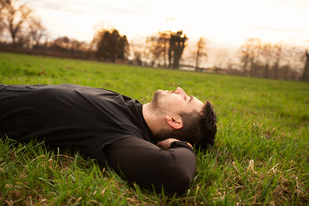 Sport fitness man relaxing  after training outdoor in a city park . Young male athlete resting...