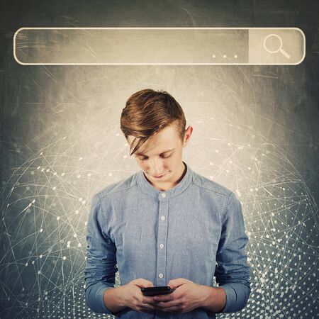 Curious teenager boy using his mobile phone browsing network search bar to find useful information...
