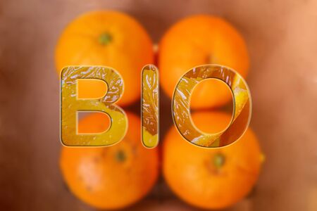 Close up of tasty orange fruits background and BIO text. Fresh orange peel, healthy organic food concept.の写真素材