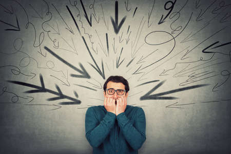 Stressful businessman, looks scared, biting his finger nails, nervous gesture, being under pressure...