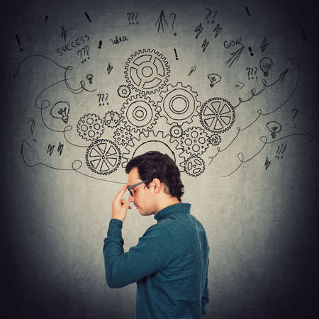 Side view portrait of pensive businessman, keeps index finger to forehead, thinking of solutions to...