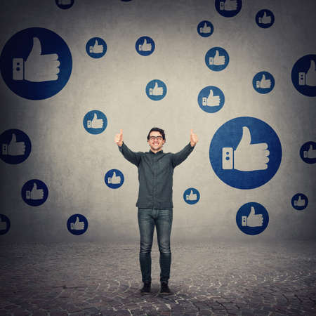 Cheerful businessman shows thumbs up positive feedback gesture. Business person wearing glasses,...