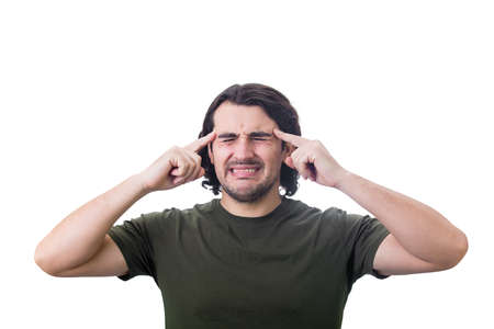 Young man, keeps fingers to his temples, clenching teeth as feels head pain. Person suffering...