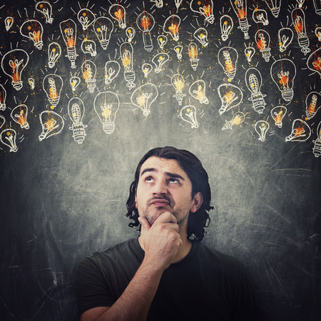 Pensive man, keeps hand under chin, thoughtful gesture, looking up suspicious at different light...