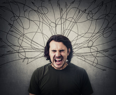 Angry and frustrated man screaming and yelling, eyes closed. Mess lines and curves sketch comes out of his head as negative emotions. Annoyed facial expression. Furious guy shouting with loud voiceの写真素材