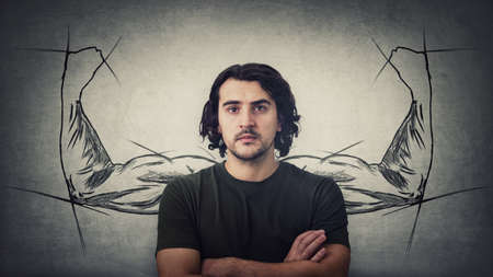 Confident guy, keeps arms crossed, strong personality, has no fears. Powerful person with biceps, muscular arms behind his back shows the inner strength. Super powers metaphorの写真素材