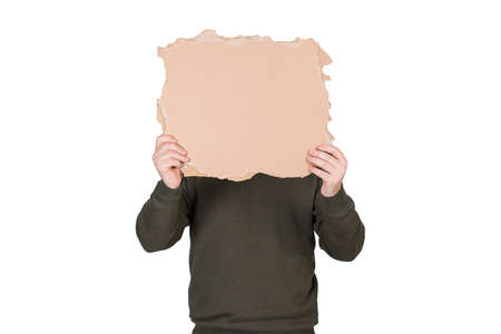 Anonymous man covers his head with a blank cardboard sheet, copy space for messages. Empty banner...