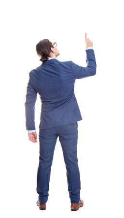 Rear view businessman in suit pointing up index finger, full length portrait isolated on white background. Business analytics conceptの写真素材