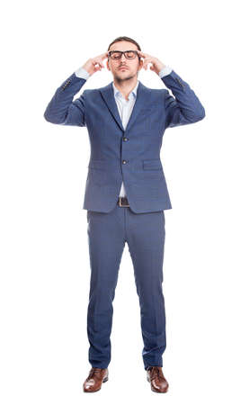 Full length portrait of young businessman keeps hands to temples focusing his thoughts, isolated on white background. Reflective business person planning and hard thinkingの写真素材