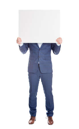 Anonymous businessman covering head with a blank banner, like a mask to hide emotions. Full length incognito person with hidden face isolated on white background. Advertising placard for warningの写真素材
