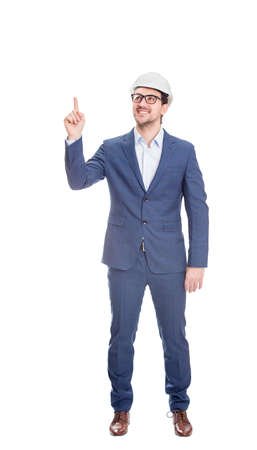 Full length positive engineer wearing protective helmet, confident pointing up his forefinger isolated on white backgroundの写真素材